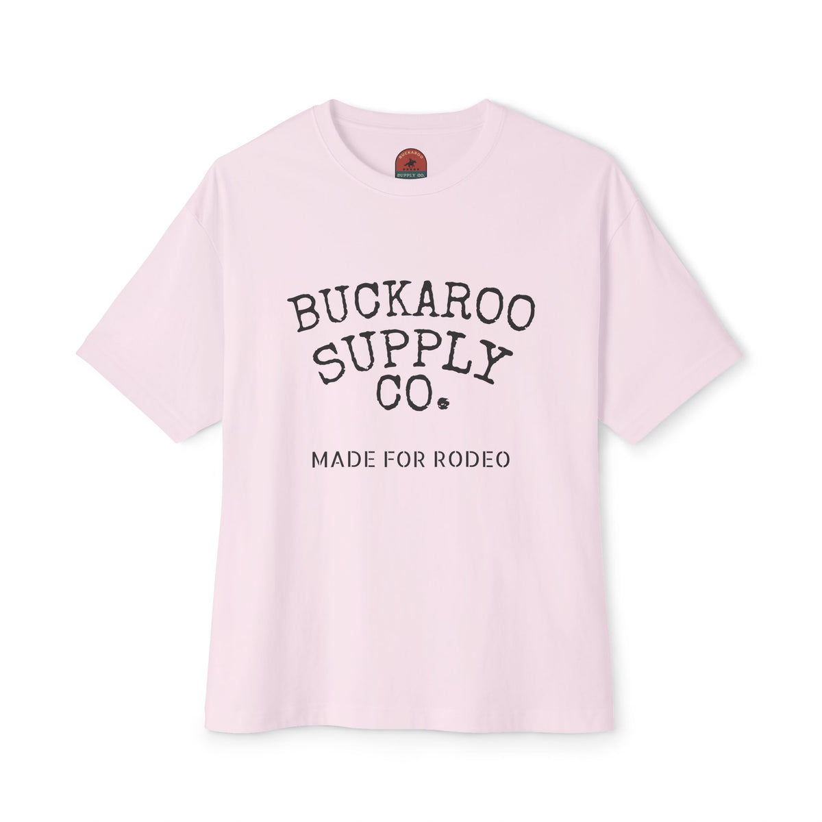 A light pink short-sleeve t-shirt with 'BUCKAROO SUPPLY CO.' and 'MADE FOR RODEO' printed in black on the front, displayed against a clean white background.