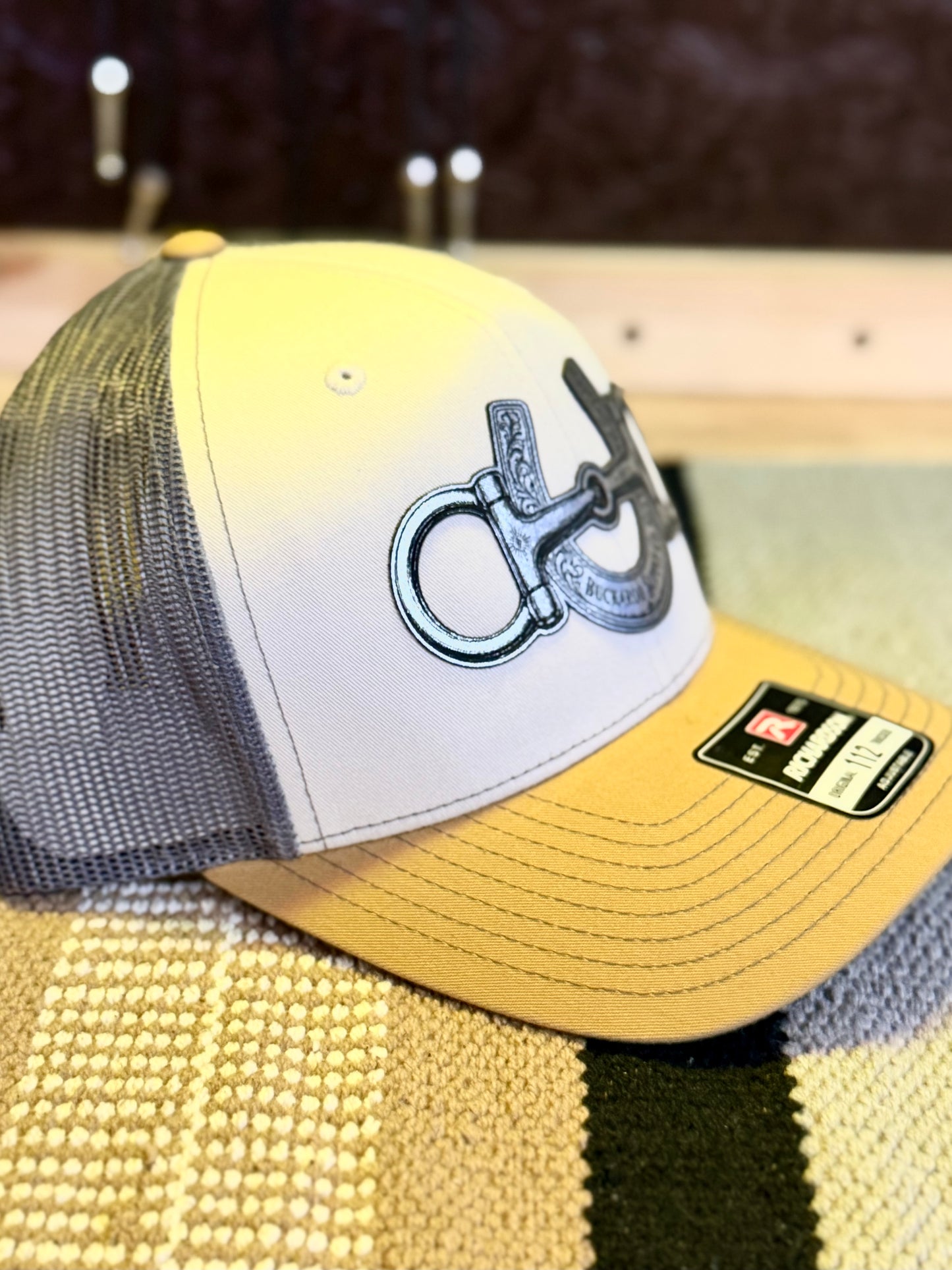 Mink Beige and Amber Gold Western trucker hat with Charcoal mesh back and silver-tone snaffle bit horseshoe design