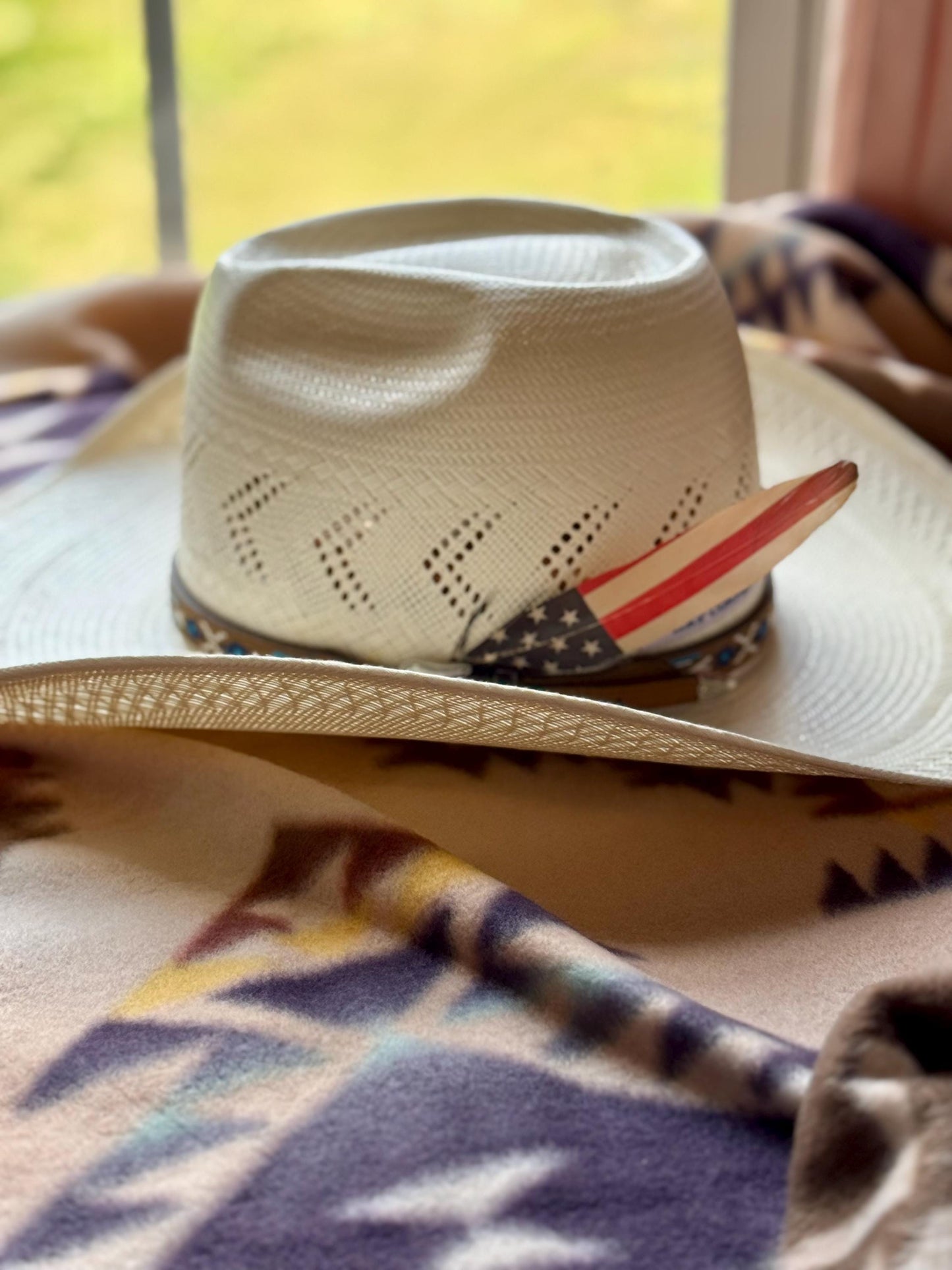 Cowboy hat with American flag design on a patterned surface