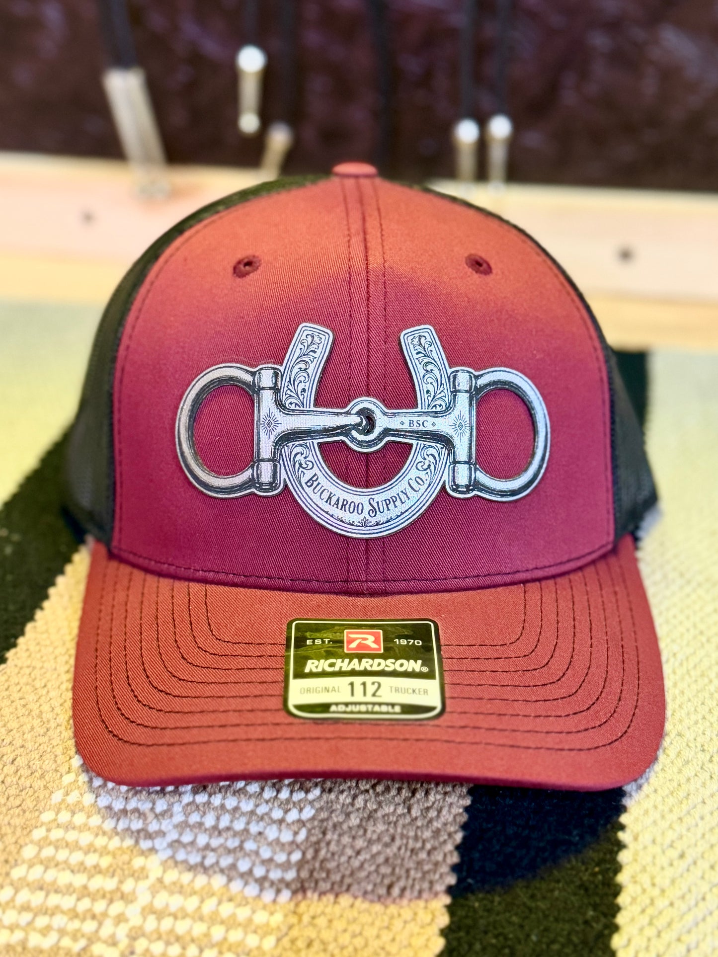 Cardinal and black Richardson 112 Western trucker hat with snaffle bit and horseshoe design