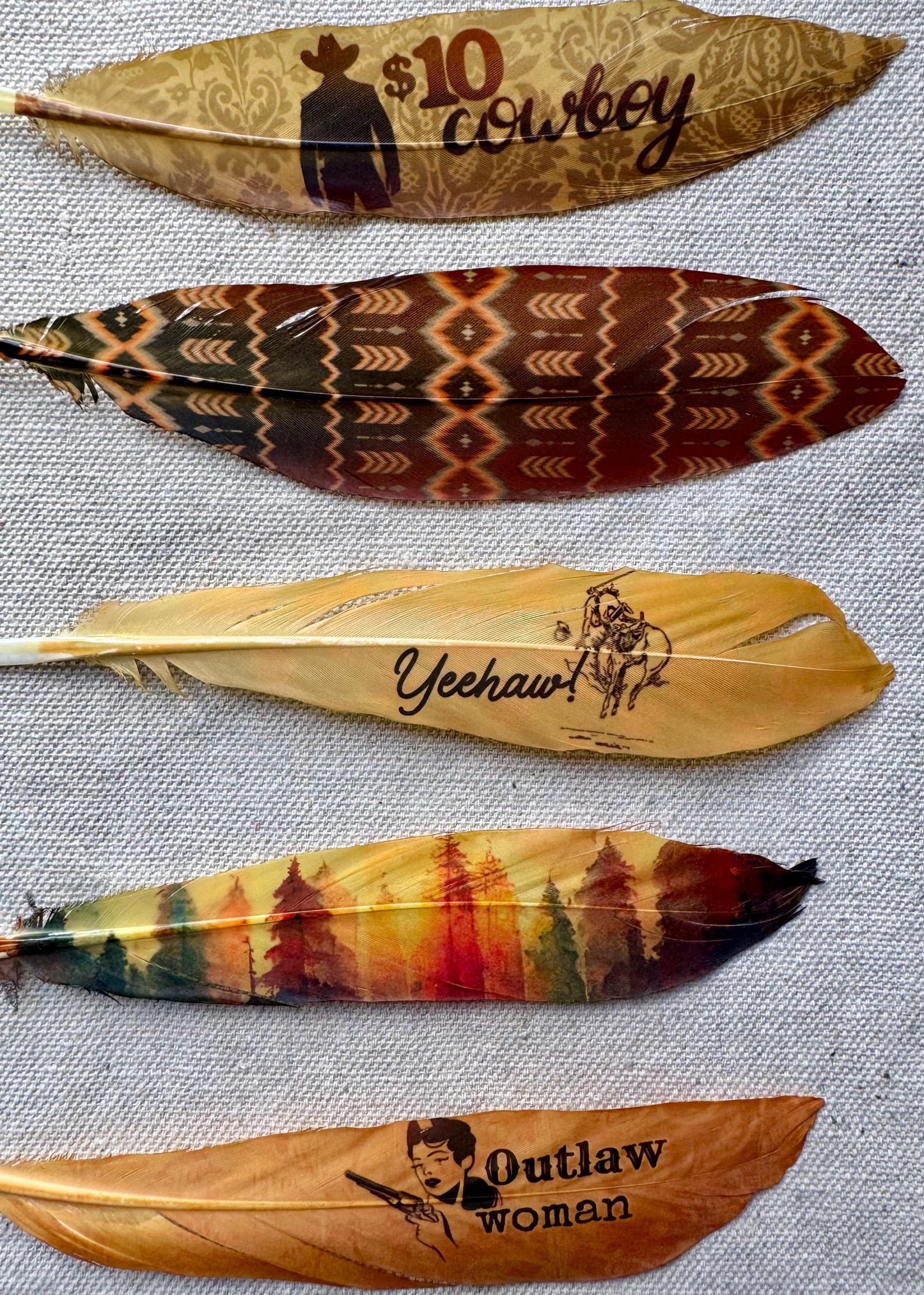 Decorative feathers with engraved text and designs on a textured surface