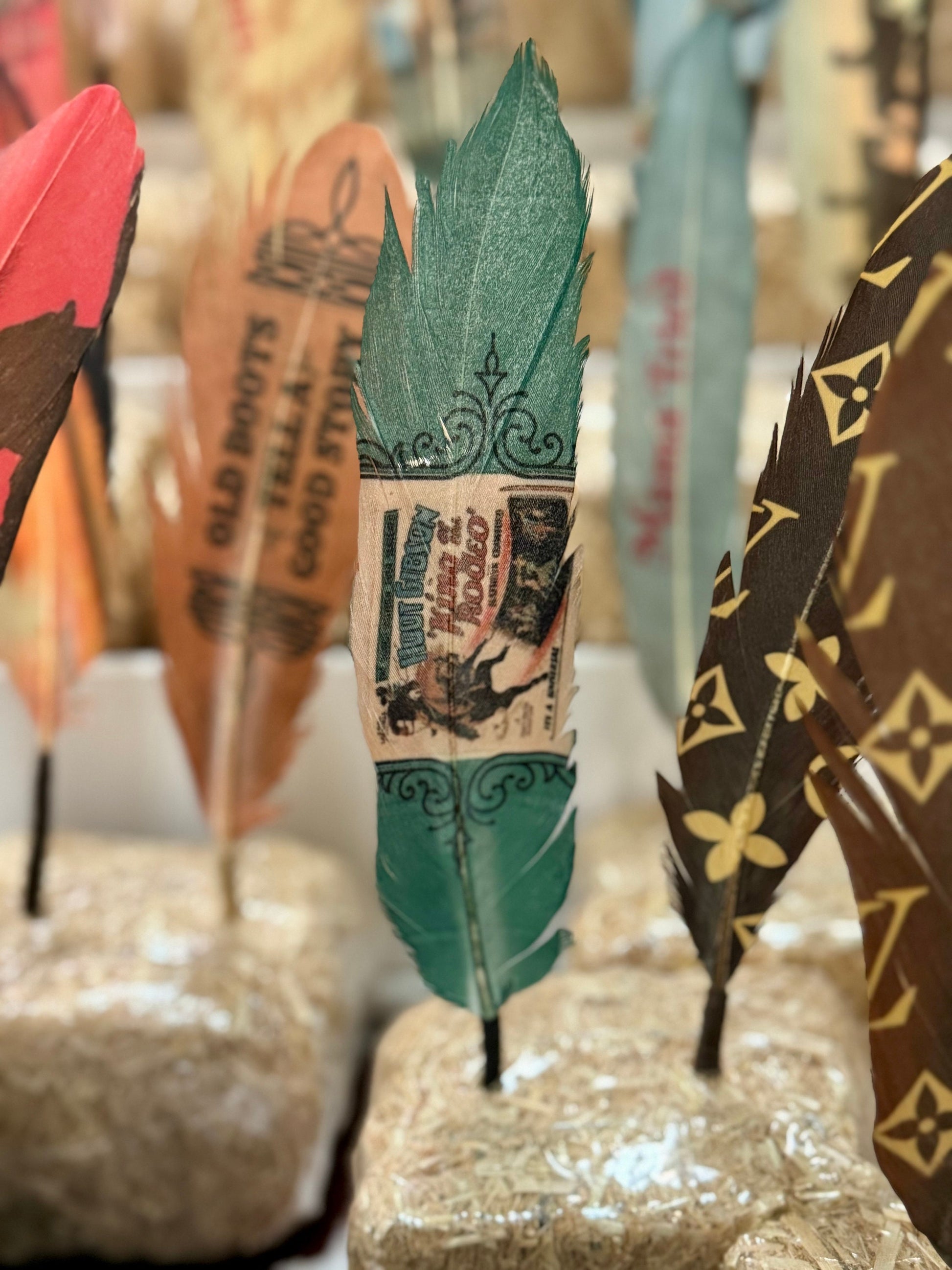 Decorative feathers with vintage-style designs on a textured surface