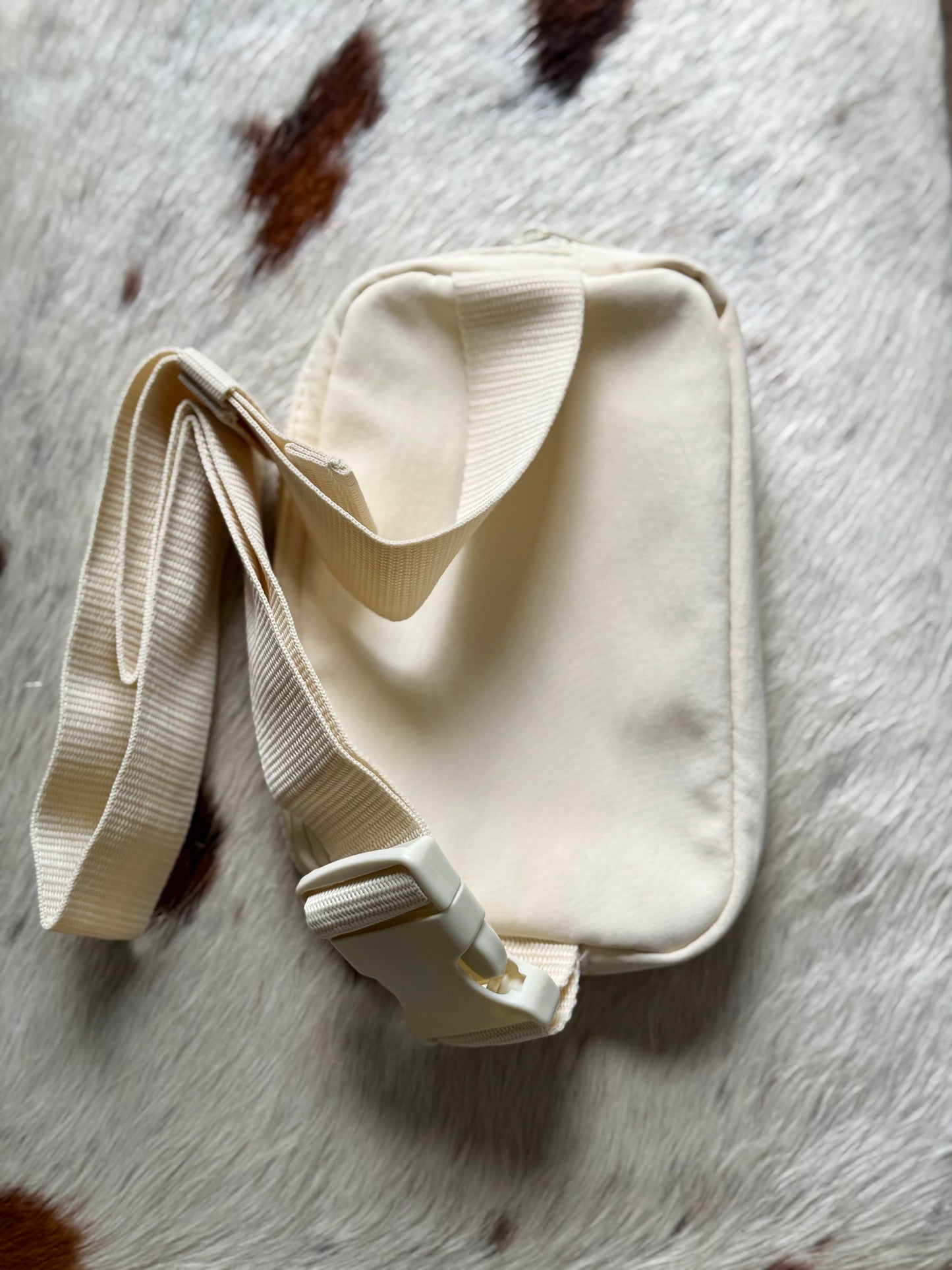 Back view of ivory Buckaroo Western Explorer Sling Bag with adjustable strap