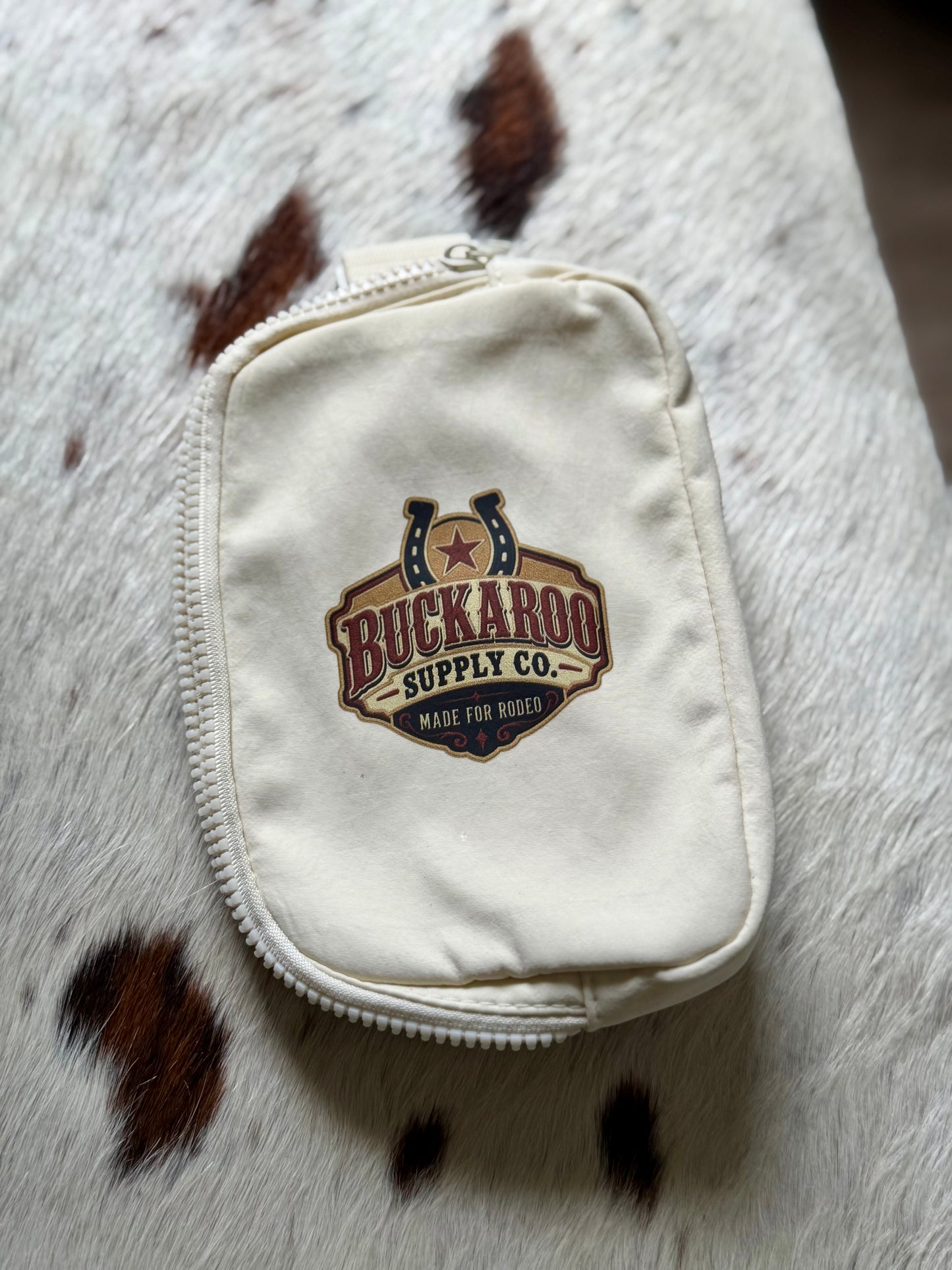 Ivory Buckaroo Western sling bag with adjustable crossbody strap on cowhide background
