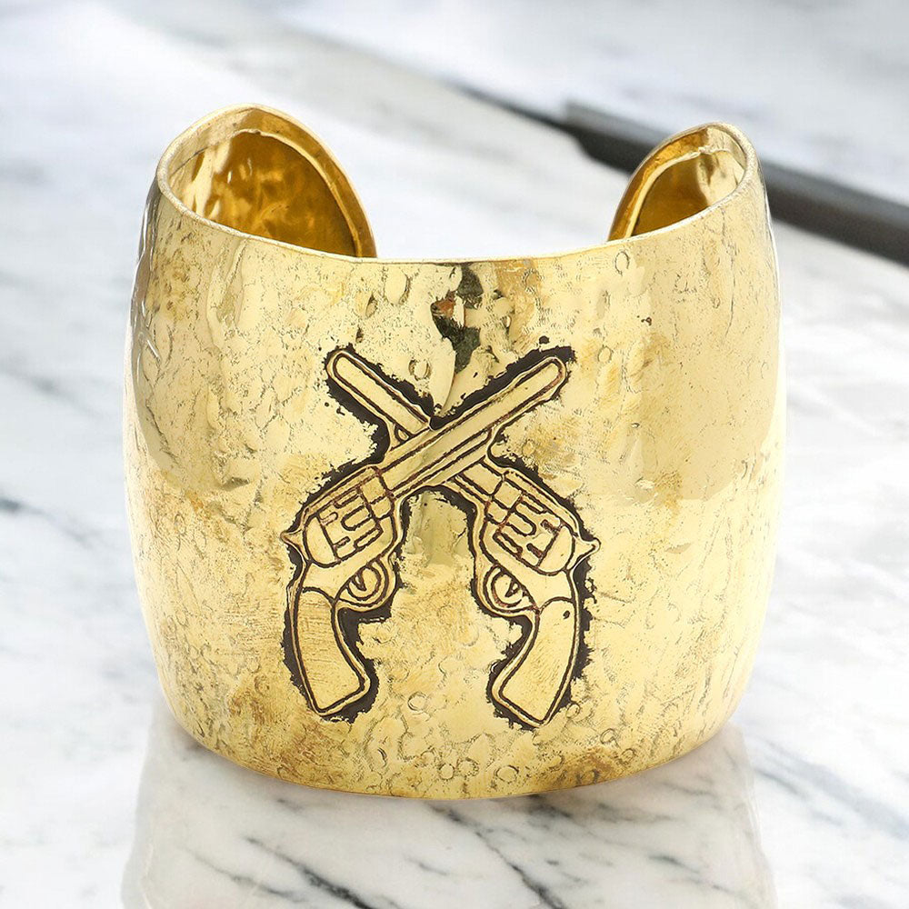 Gold hammered metal cuff bracelet with crossed revolver design