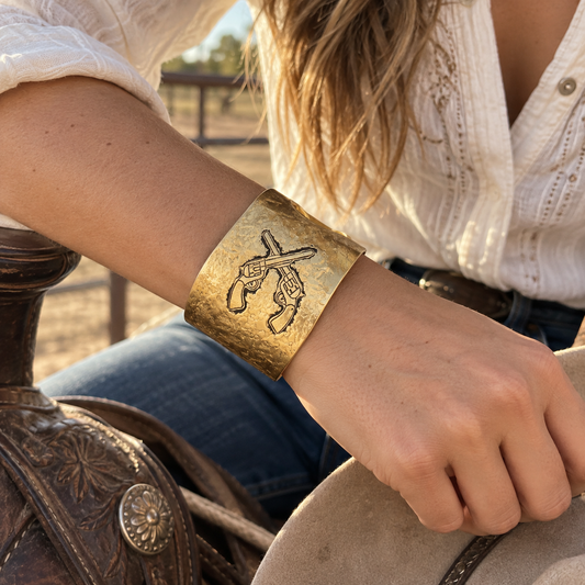 Cowgirl wearing gold crossed revolvers Western cuff bracelet