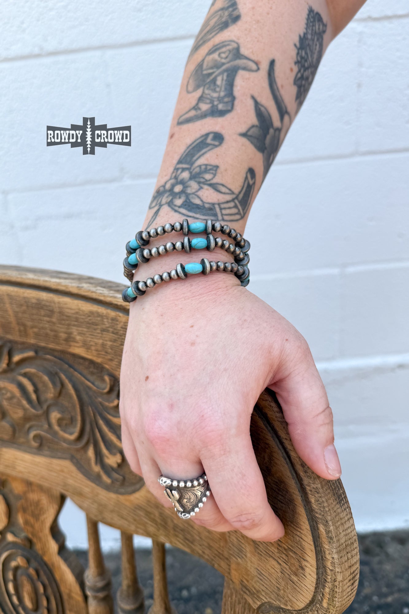 Silver-tone and turquoise cowgirl bracelet stacked on wrist