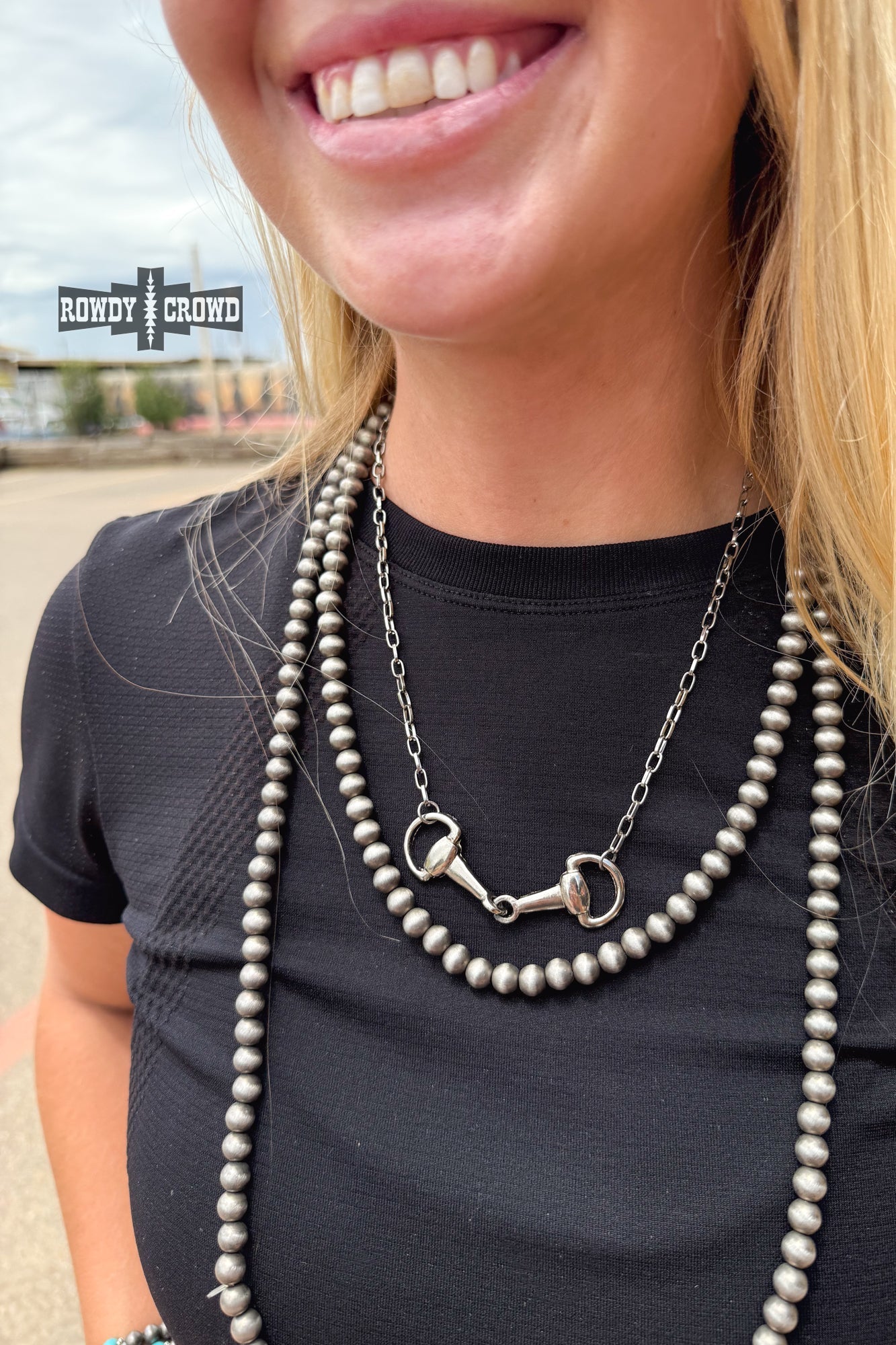 Silver snaffle bit necklace layered with Western jewelry