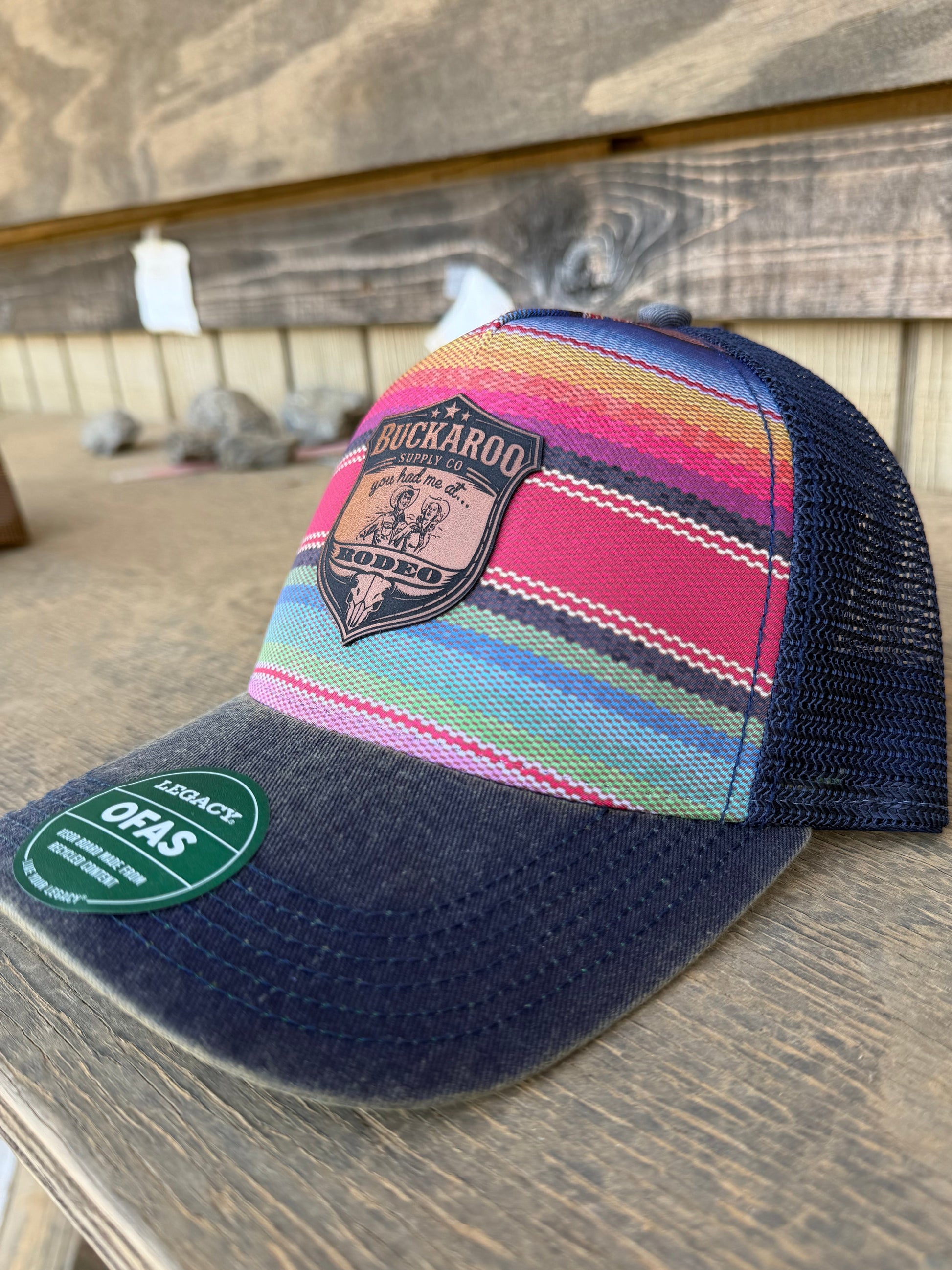 Colorful striped trucker hat with a brand logo on a wooden surface