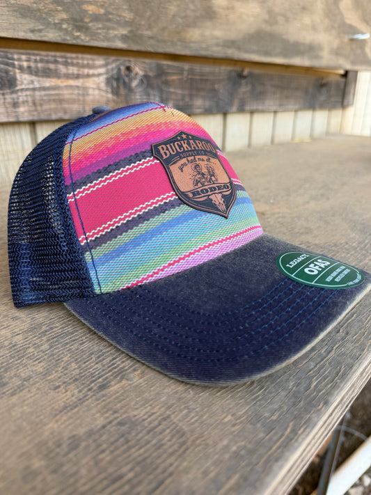 Colorful striped Legacy trucker hat with a logo on a wooden surface
