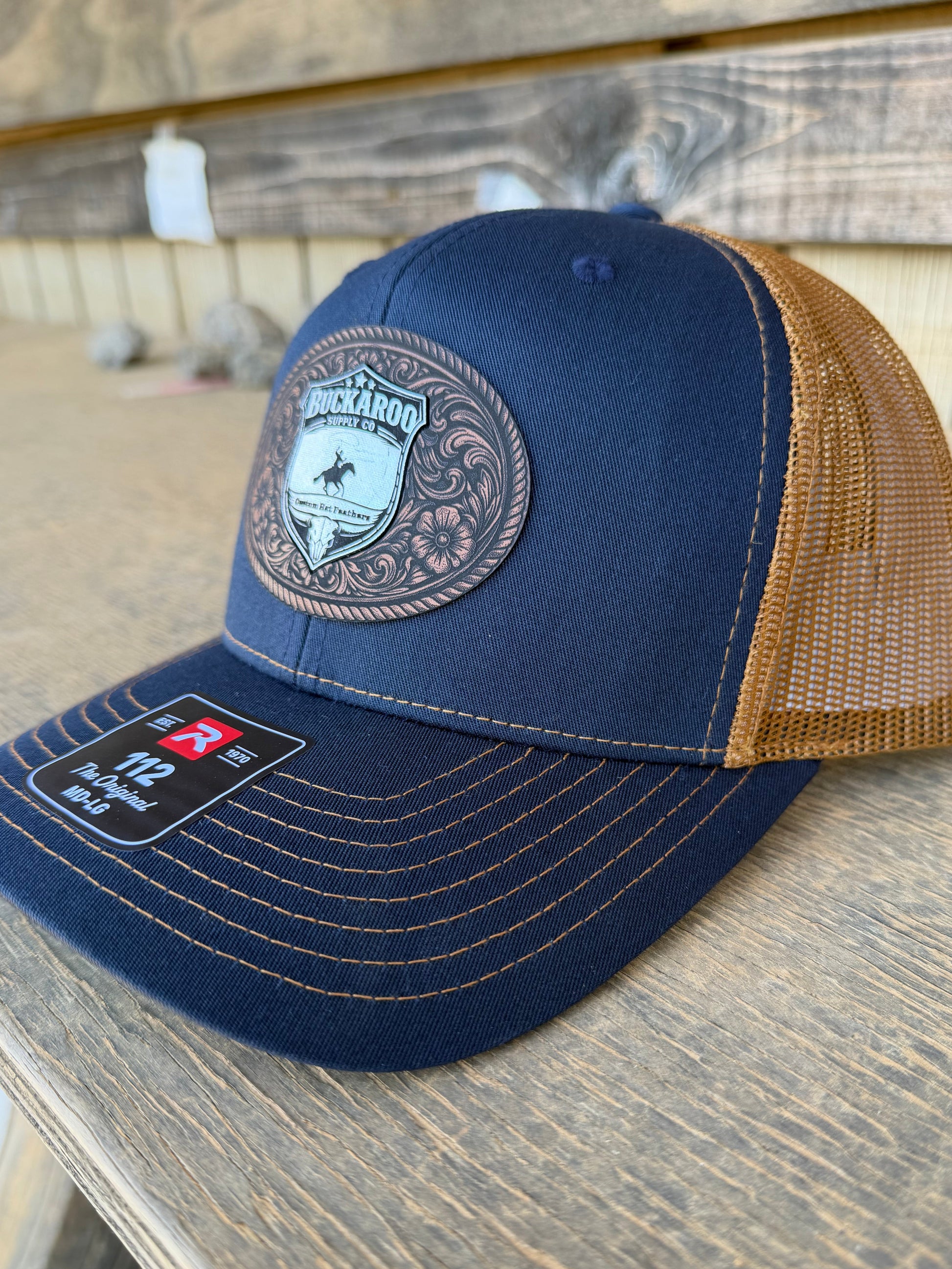 Blue and brown trucker hat with a patch on a wooden surface