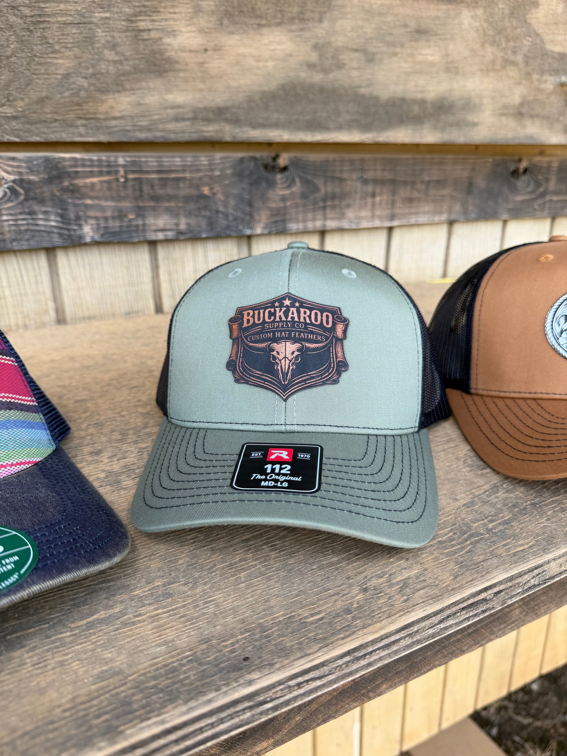 Two baseball caps on a wooden surface with visible branding.