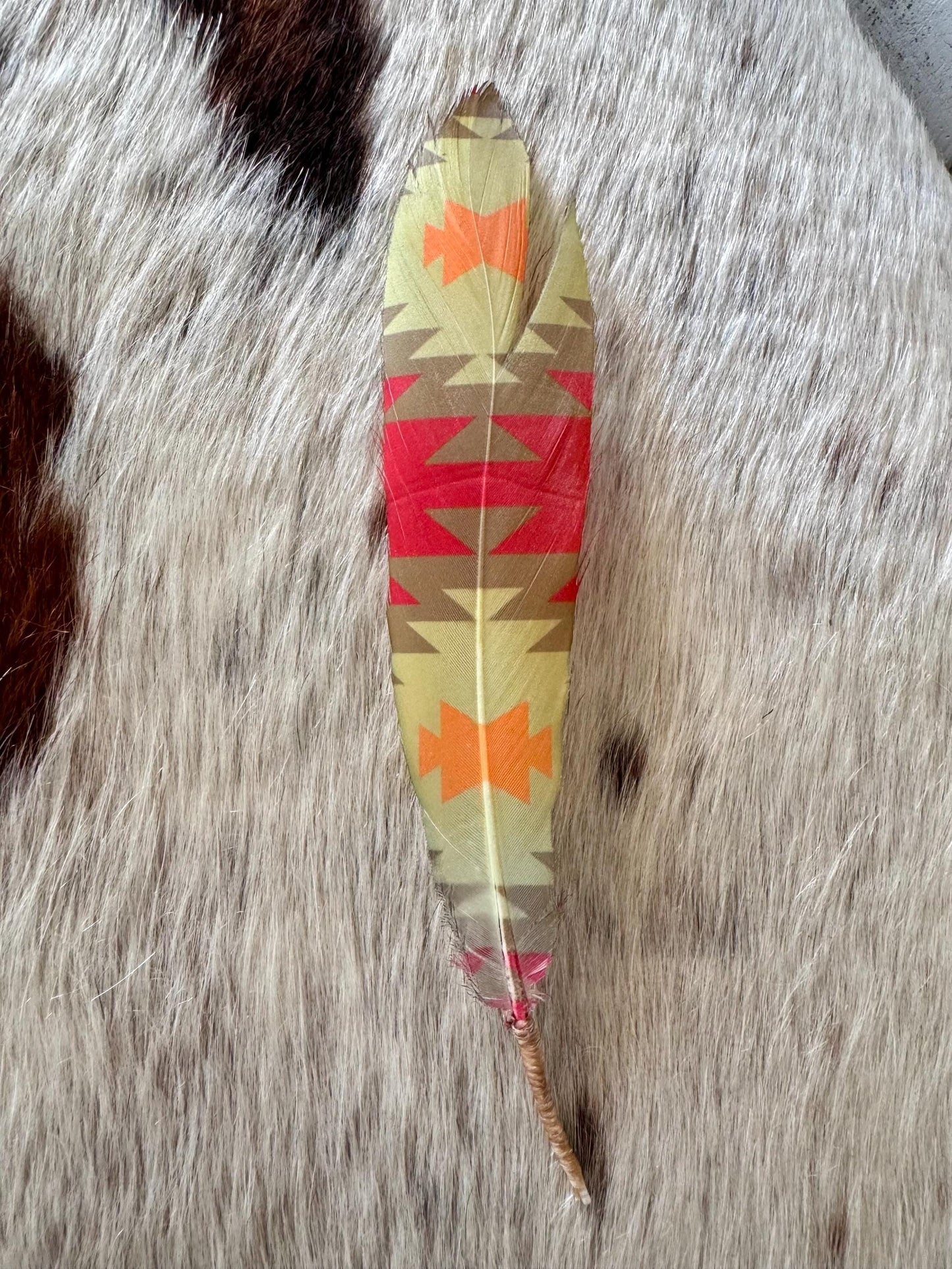 Southwestern cowboy hat feather with coral orange and tan tones