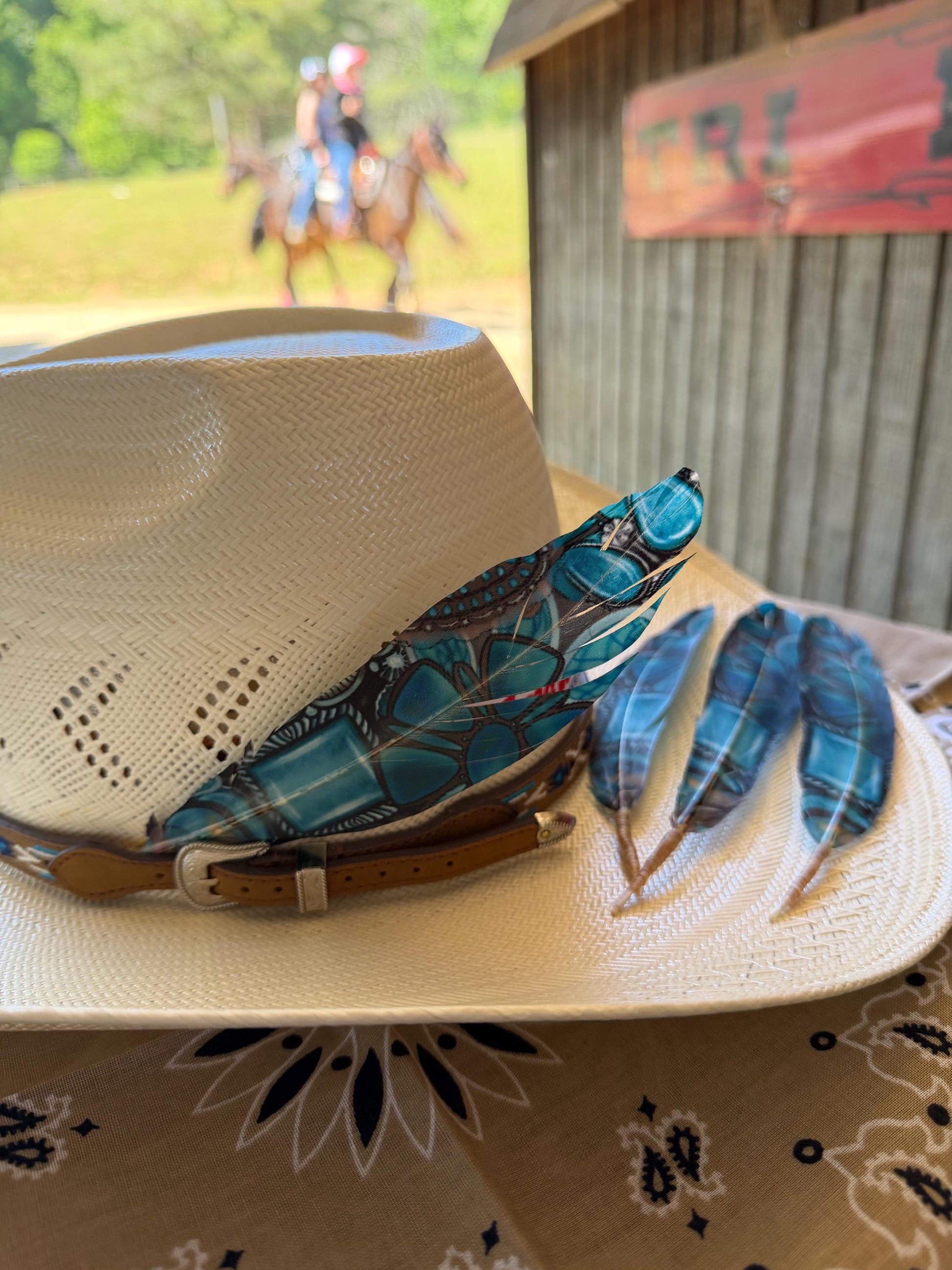 Turquoise Dream Western hat feather on a cream straw cowboy hat with blue accent feathers