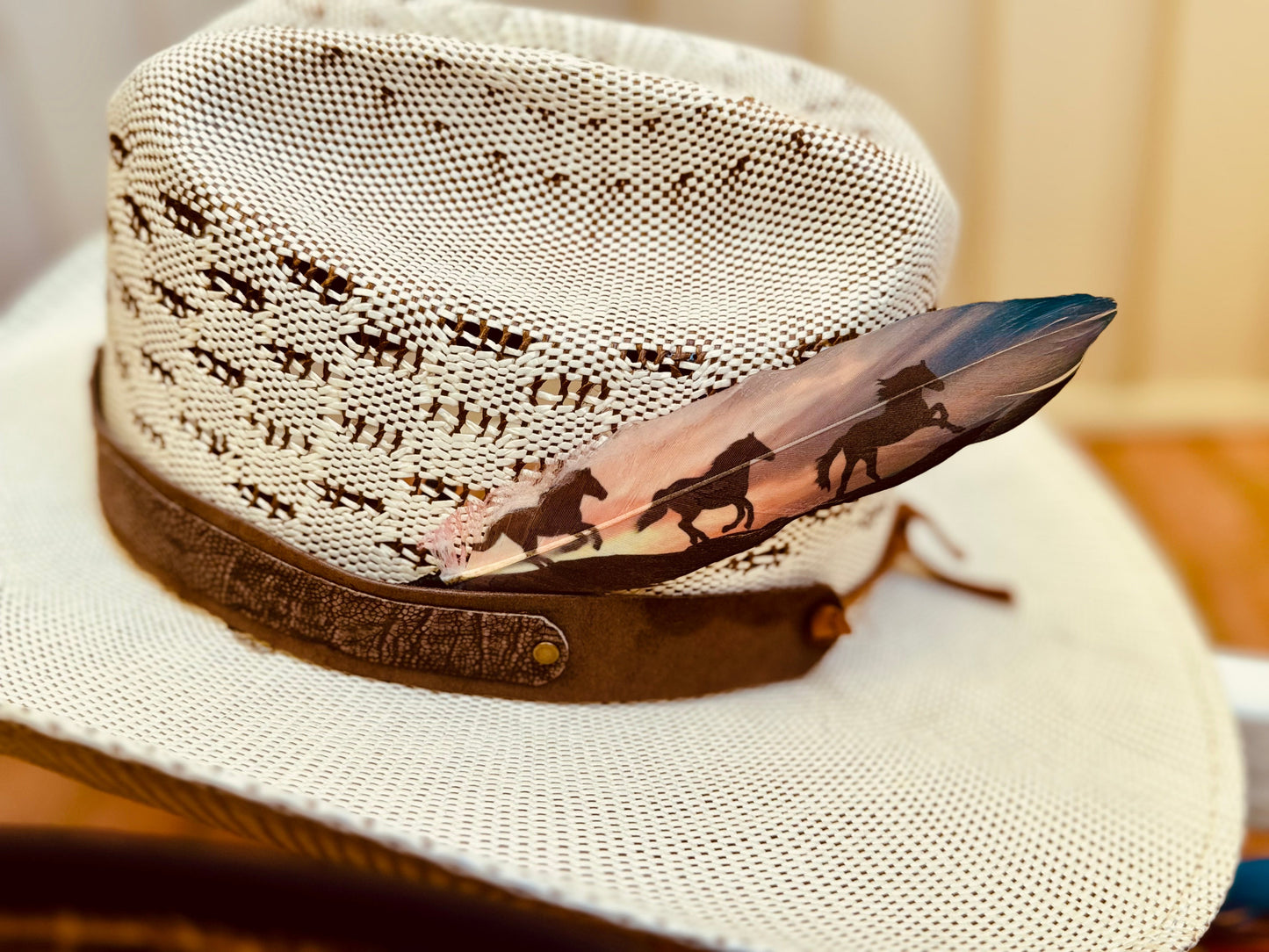 Close-up of a white cowboy hat with a decorative Buckaroo Supply Co. hat feather on a blurred background