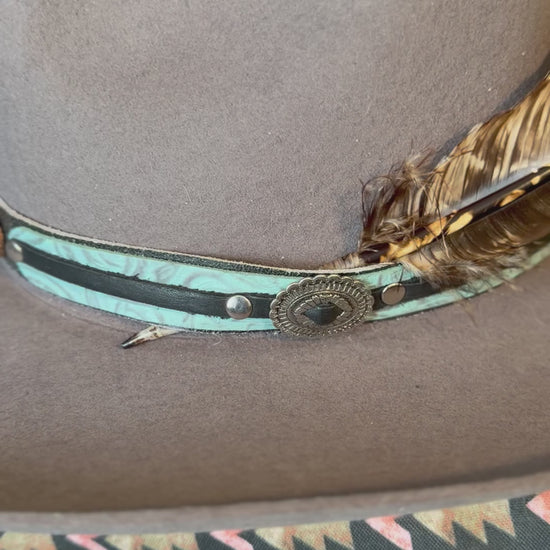 Large brown and cream turkey quill feather styled on a Western hat band
