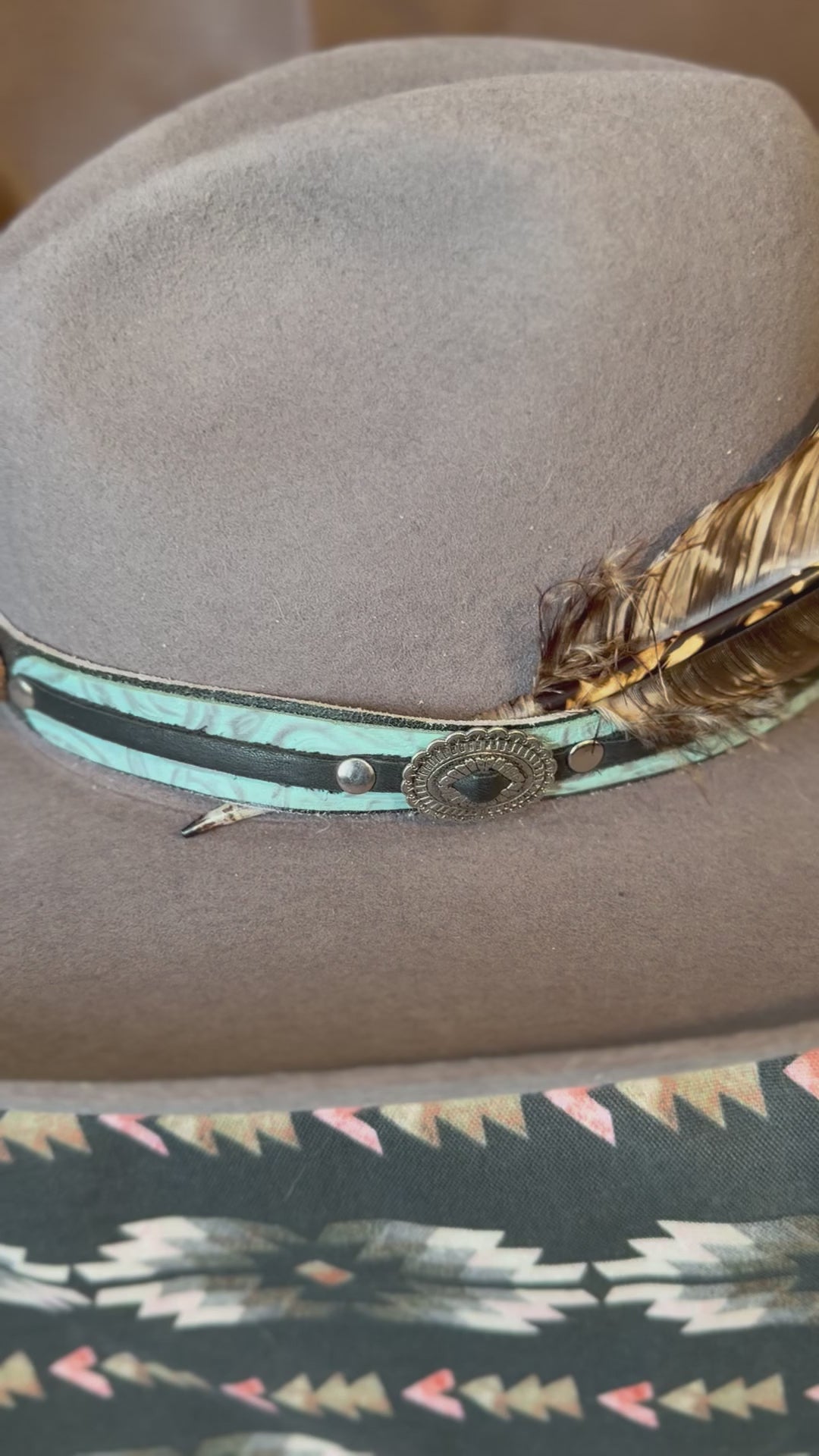 Large brown and cream turkey quill feather styled on a Western hat band